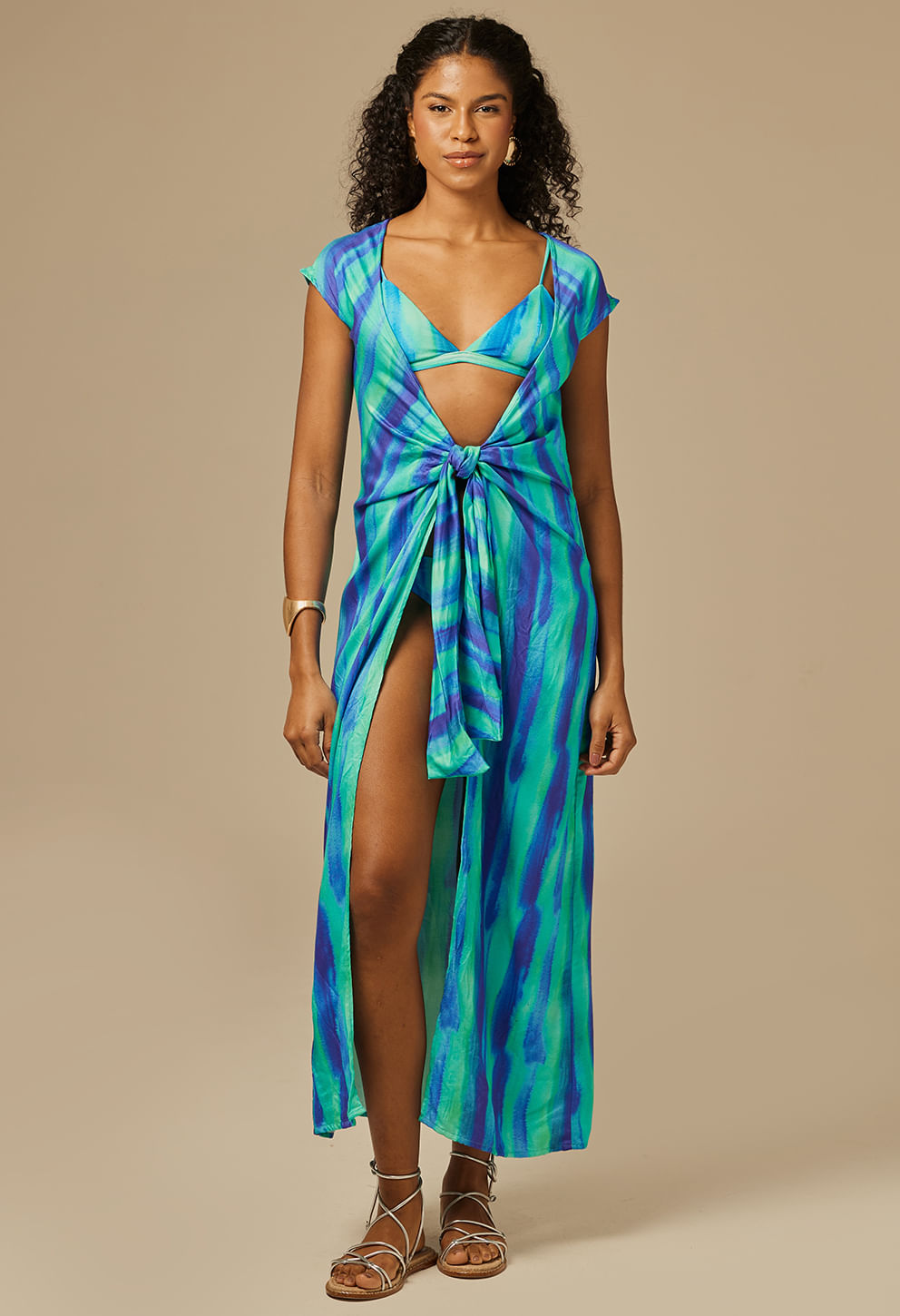 Mulher negra usando saída de praia longa azul e verde com mangas curtas e amarração frontal