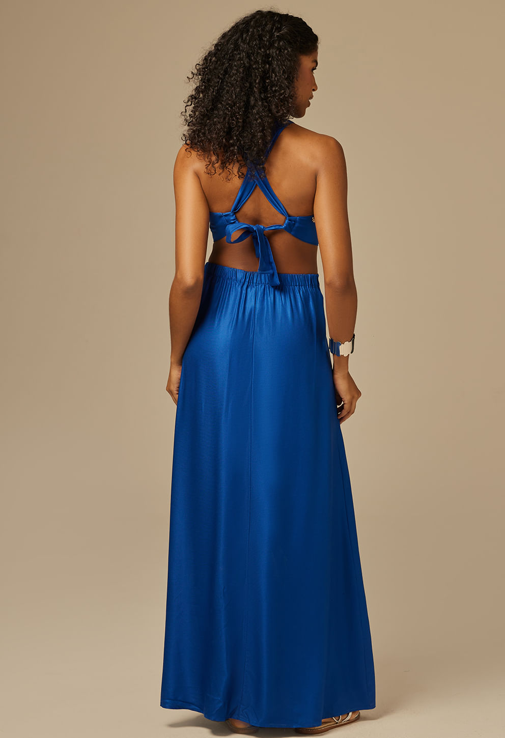 Vista traseira do vestido longo azul royal mostrando amarração nas costas e cós com elástico.