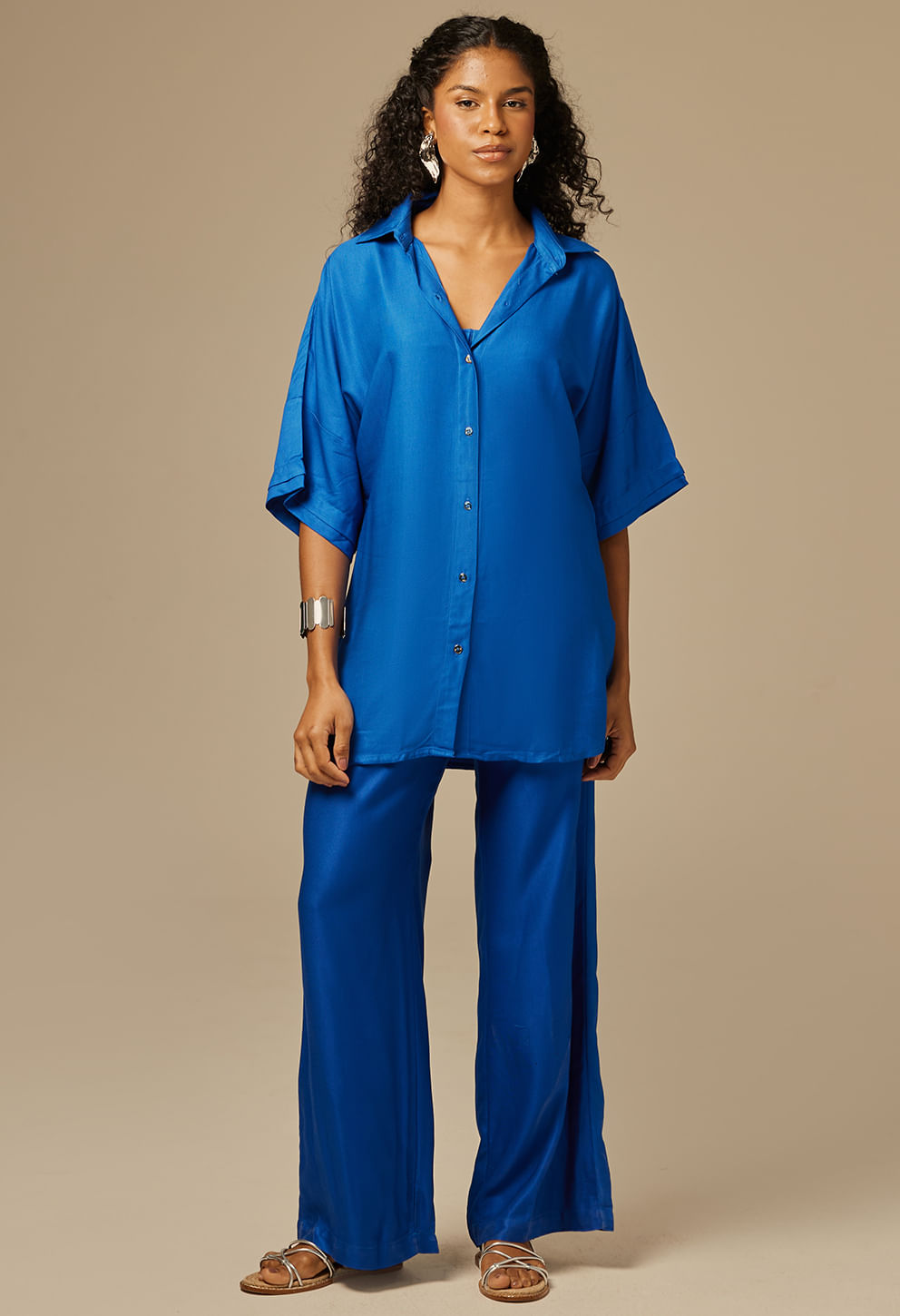 Mulher usando camisão azul royal oversized com botões frontais e gola tradicional